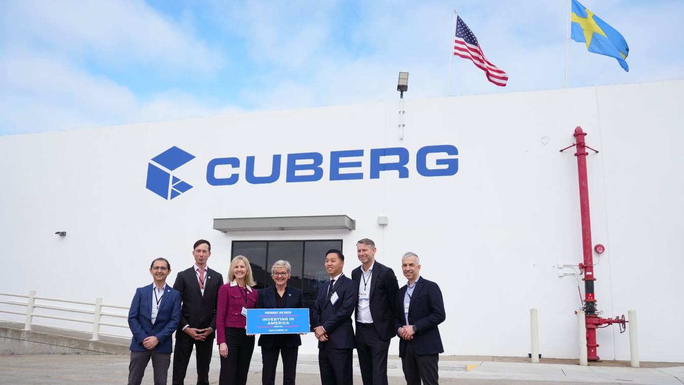 Standing alongside senior executives from Cuberg and Northvolt, U.S. Secretary of Energy holds a sign that reads: "President Joe Biden. Investing in America. Invest dot gov. San Leandro, California."