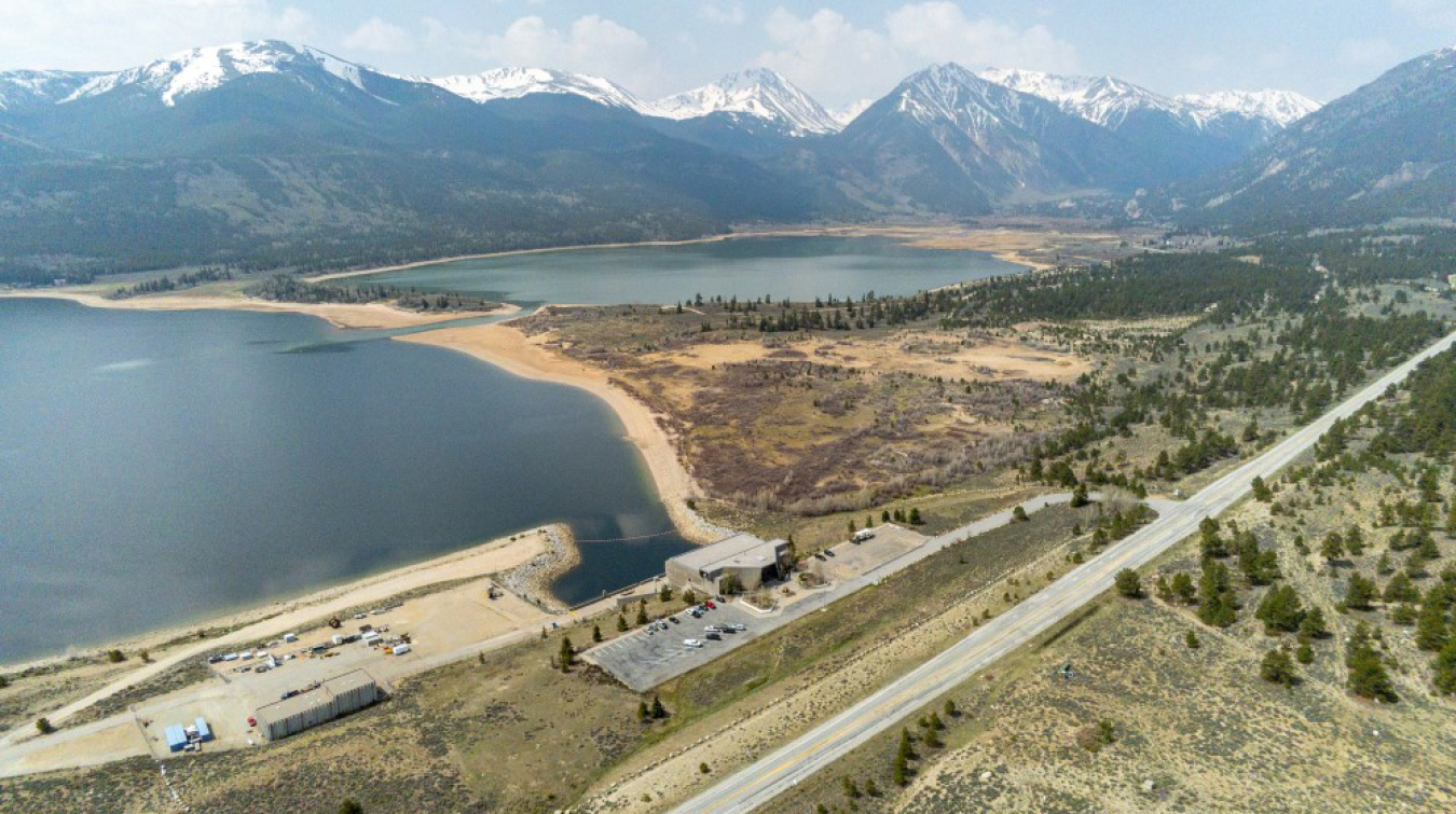 A photo of two water reservoirs with mountains behind them.