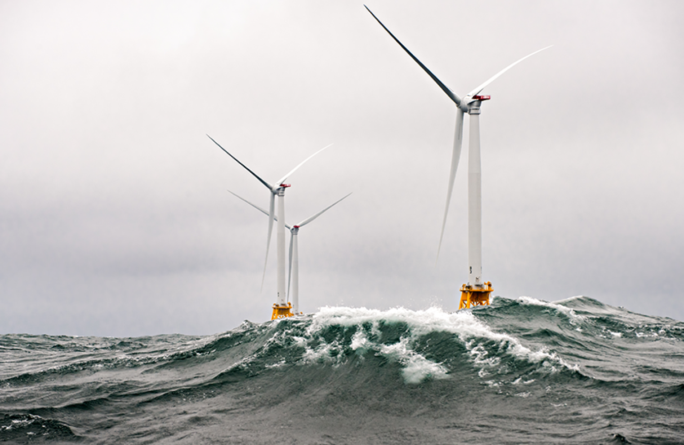 Offshore wind turbines at sea with clouds.