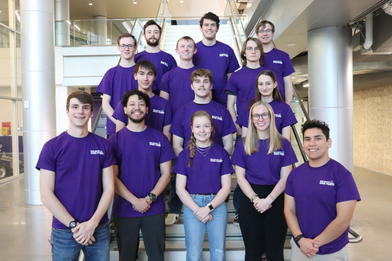 A group of people in matching shirts standing on a staircase.