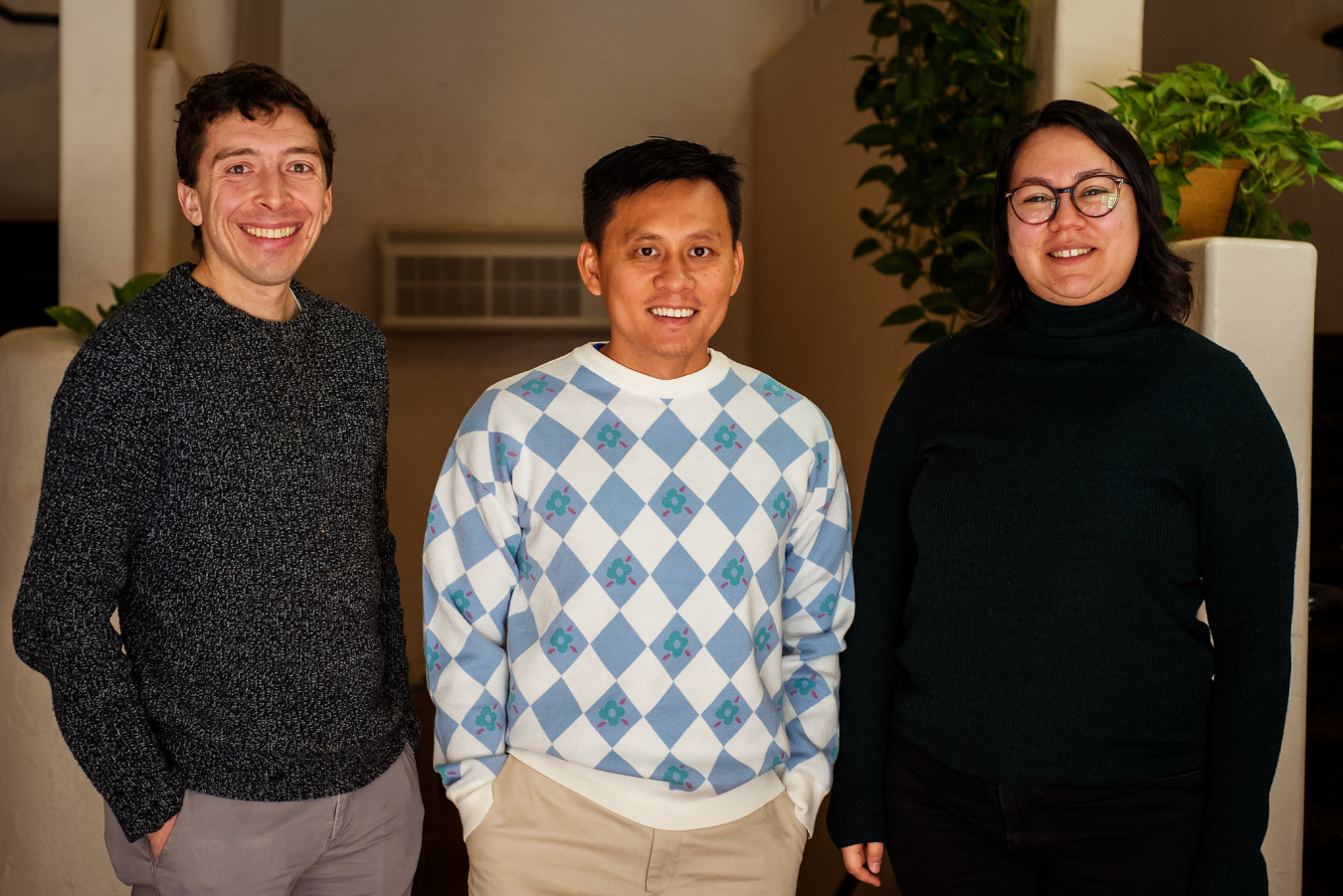 Three people pose and smile for the camera.