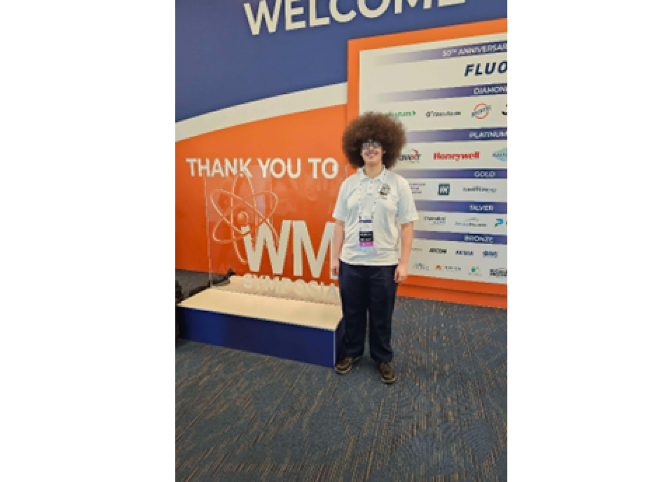 Kurt Abraham standing in front of Waste Management Symposia sign