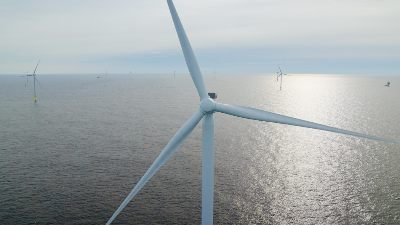 Close-up of a water-bound wind turbine with other wind turbines further in the background.