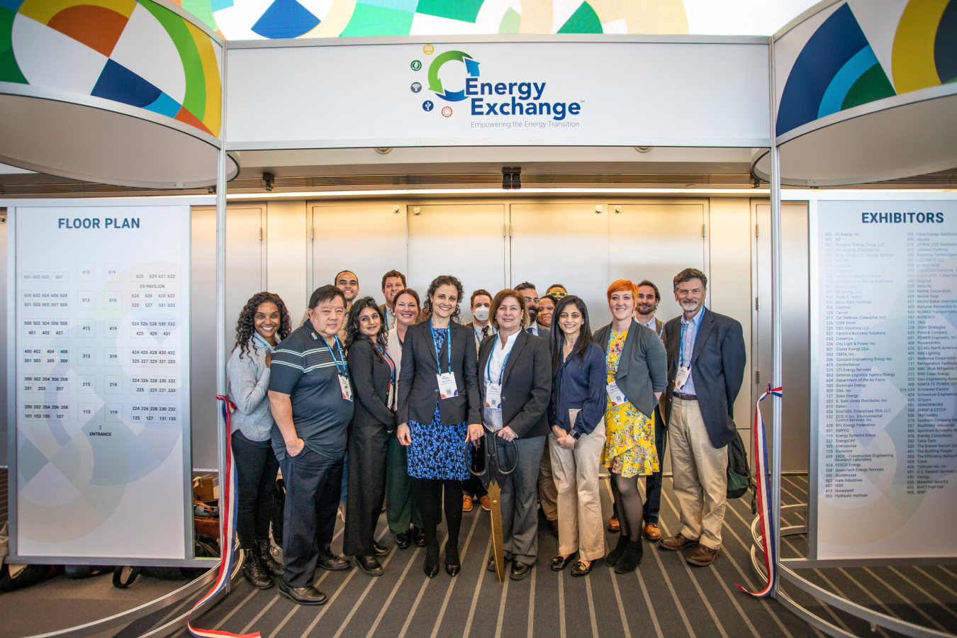 A group of people pose for a photo in front of a conference sign.