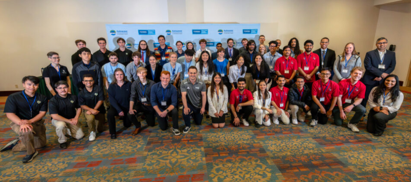 Competitors from the 2024 Hydropower Collegiate Competition standing in front of a competition banner.