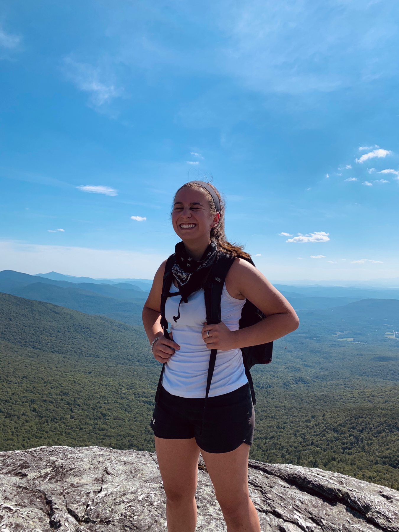 Anderson smiling on the summit of a mountain.