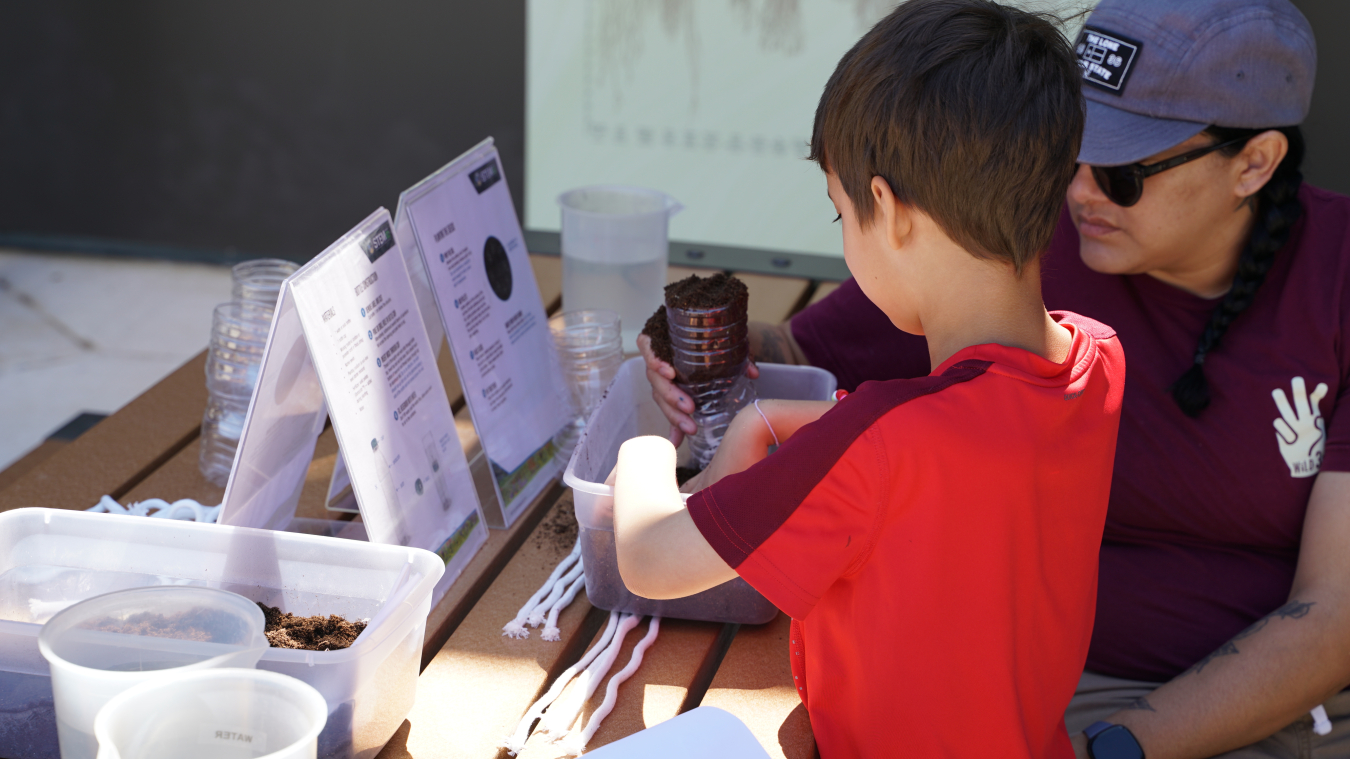 A family participates in the STEM with LM Bottle Grower System activity.