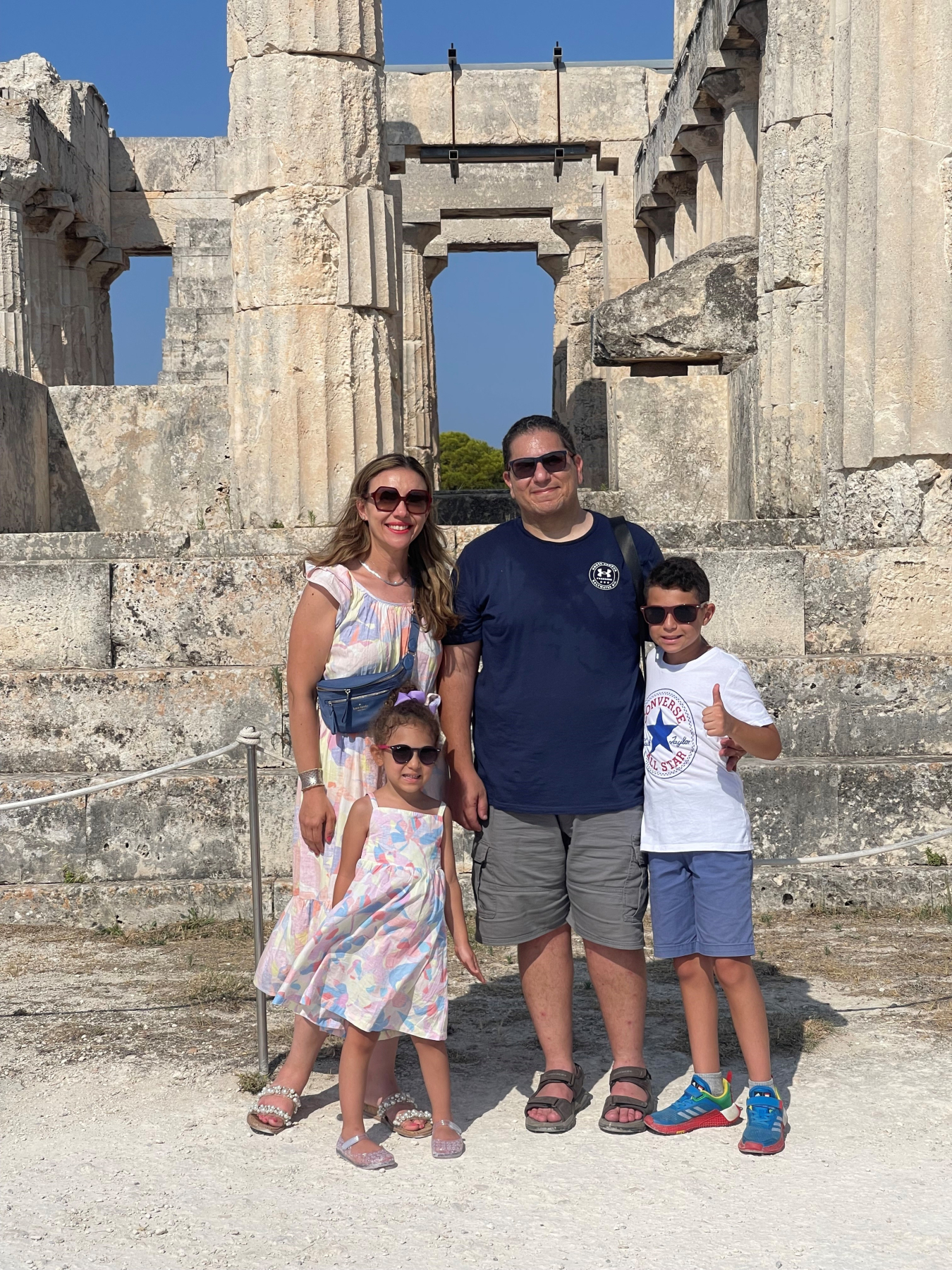 Alaa Elwany posing for a photo with his wife and two young children in front of ruins