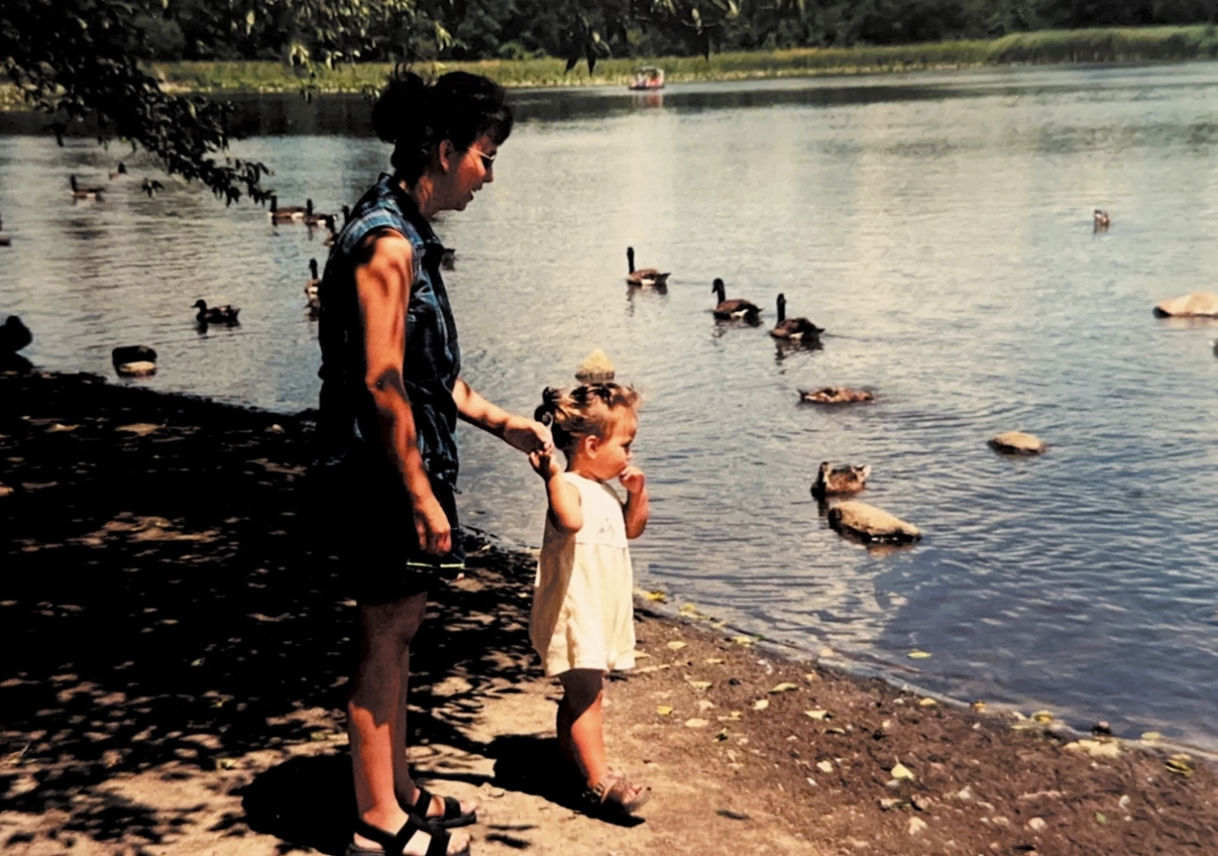 Megan Anderson as a little girl looking at geese swimming in a pond.