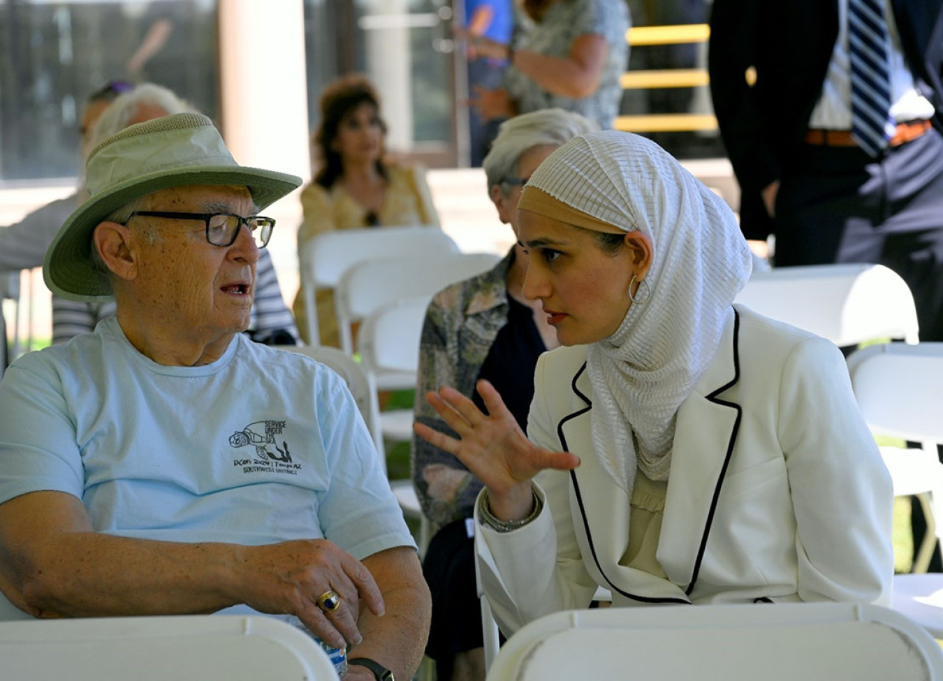 Dr. Khatlani speaks with a former worker in the audience in between presentations.