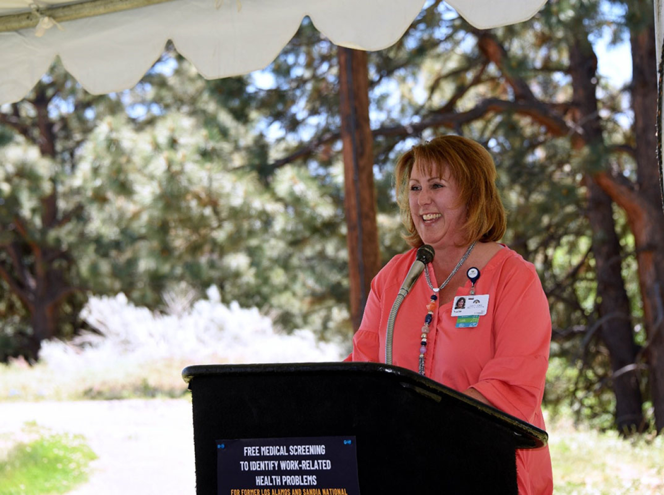 Tracie Stratton, CEO of Los Alamos Medical Center, laughs at the podium while speaking to the audience.