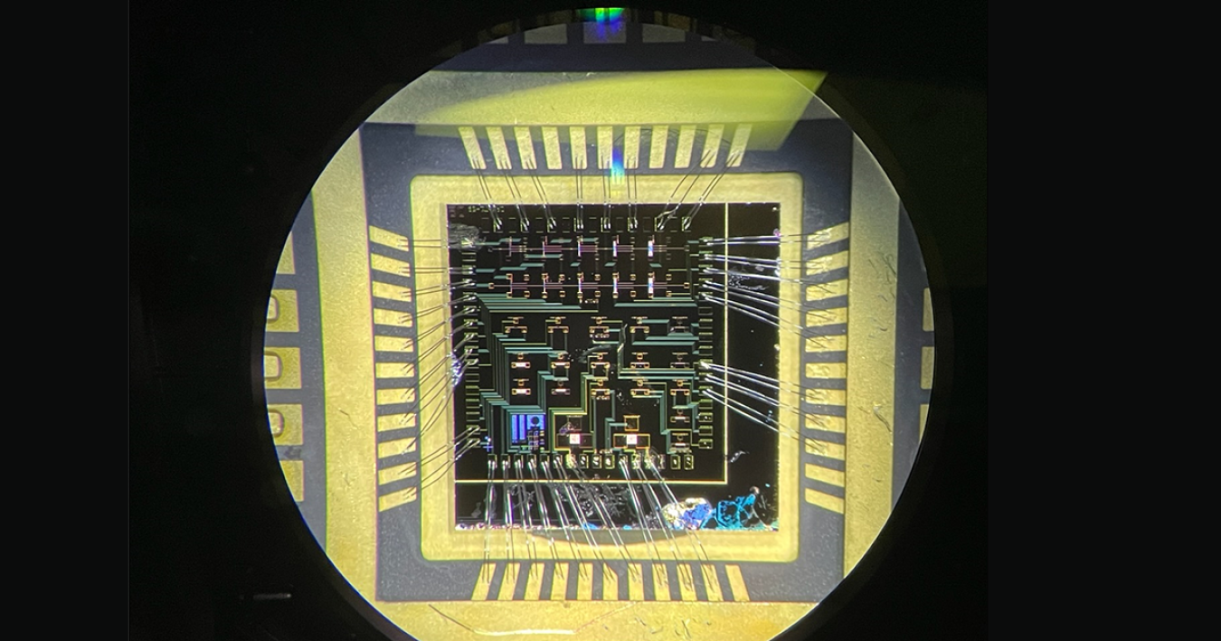 Circuitry viewed through a microscope against a black background.