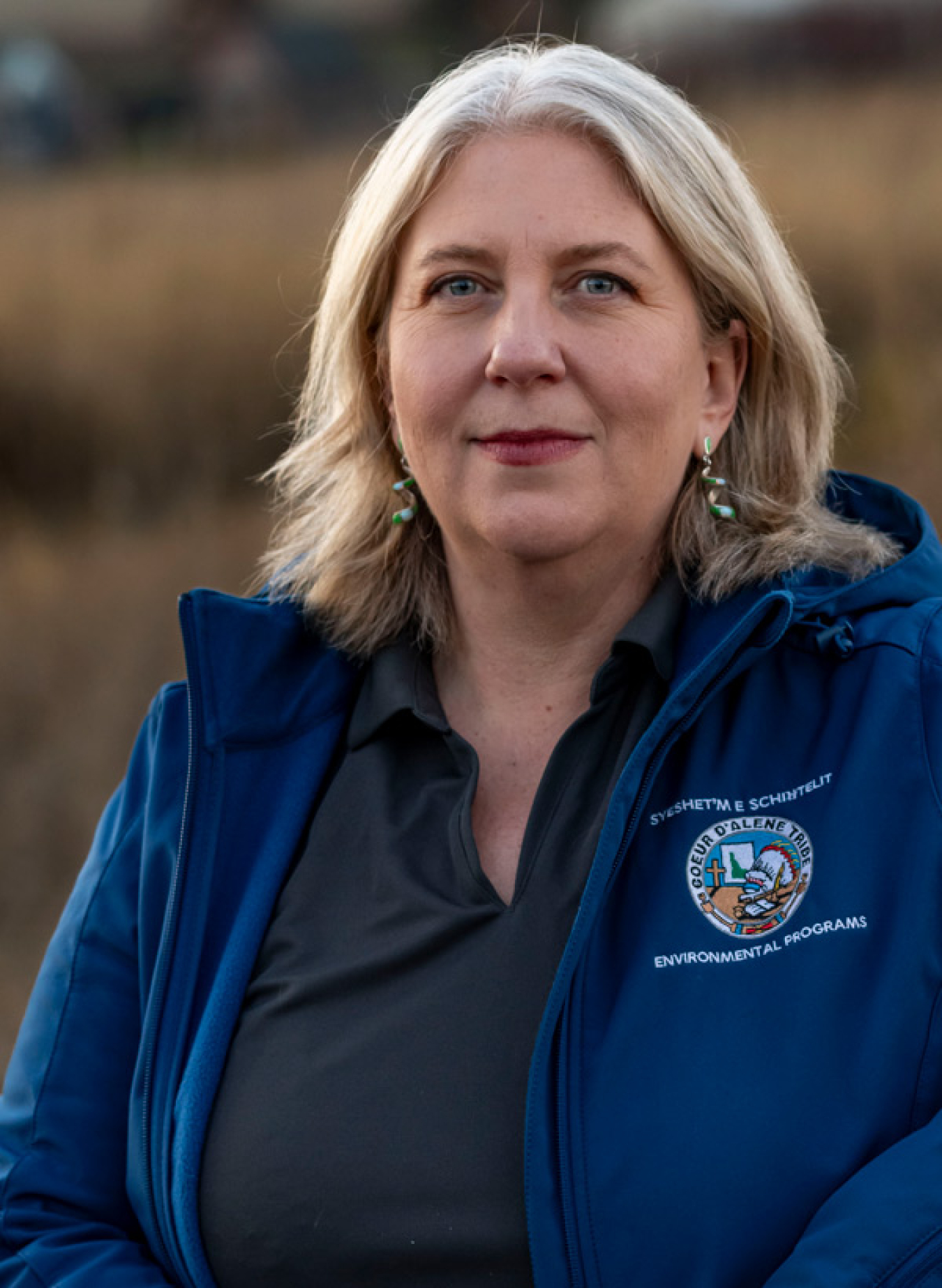 A blonde middle age woman with a blue Environmental Programs jacket.