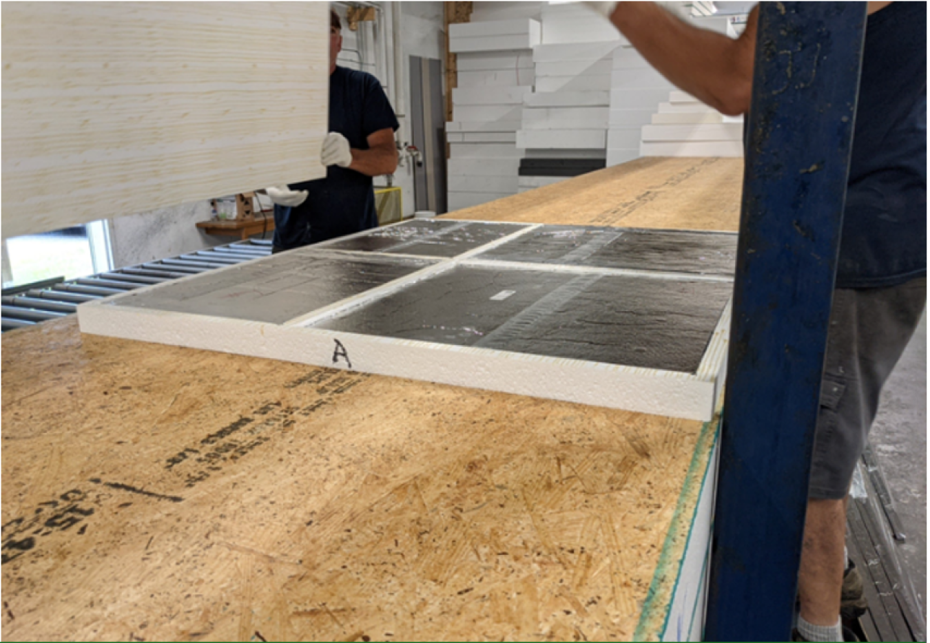 Insertion of VIPs into an expanded polystyrene foam tray to assemble a prototype retrofit panel for testing.