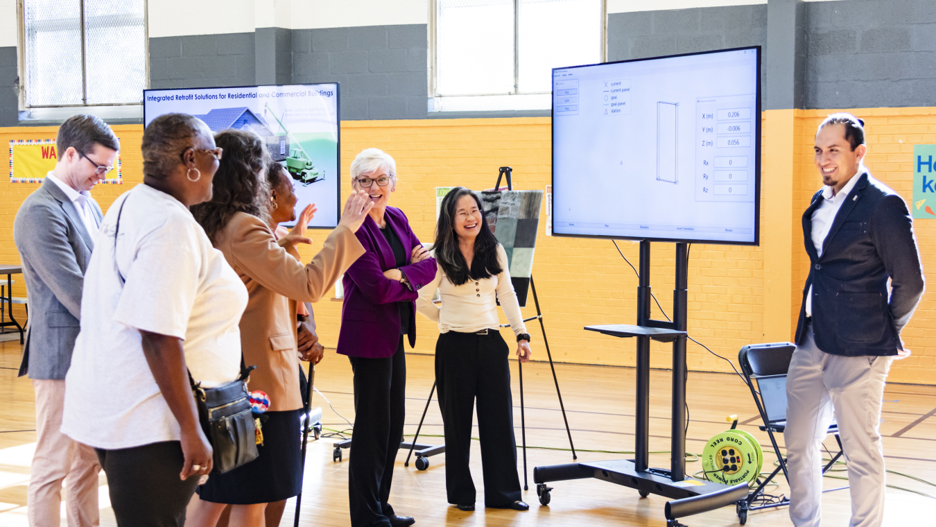 Group of people standing in a room next to a display.