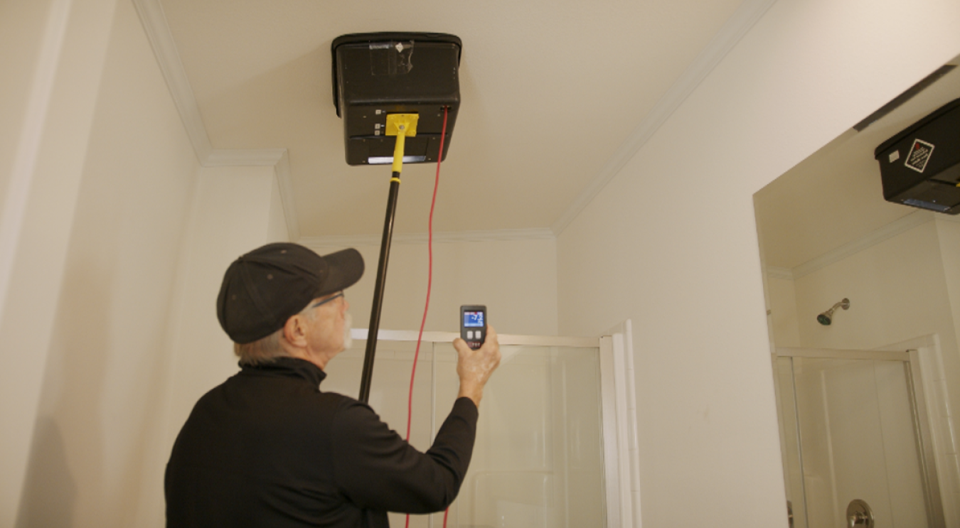 Measuring bathroom fan airflow in a new manufactured home—part of the simple duct and air leakage protocol developed for new manufactured homes.