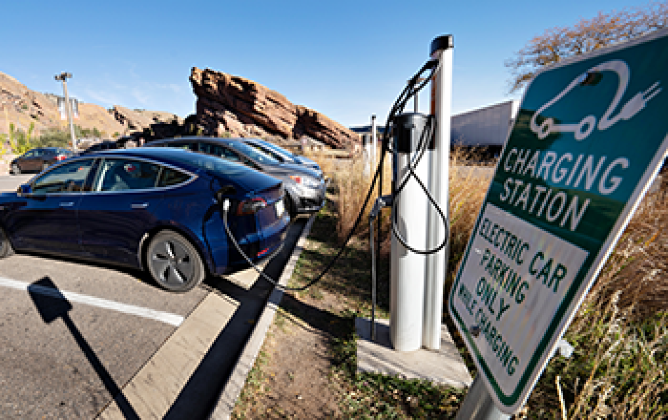 Electric vehicle parked and charging at a charging station in the Red Rocks Park in Colorado.