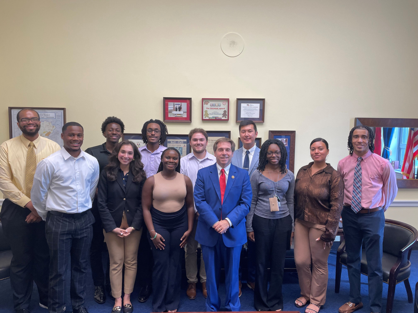 A group of young Department of Energy interns with a Congressman in a blue suit in the middle of the group photo 