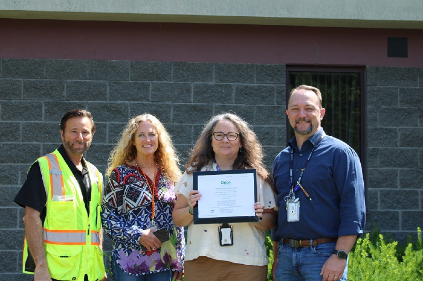 Team members display a certificate.