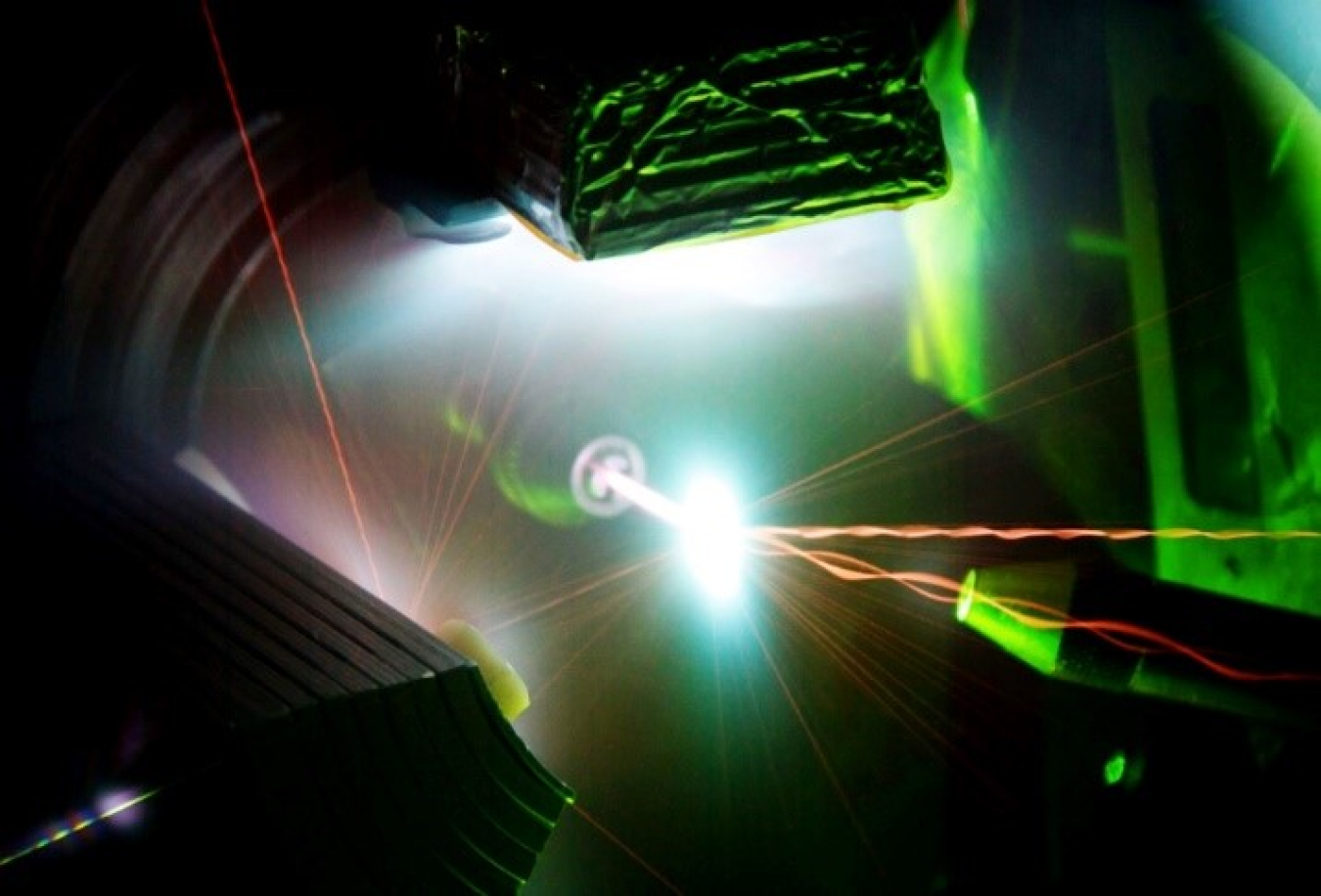 Invisible infrared light from the 200-trillion-watt Trident Laser enters from the bottom to interact with a one-micrometer thick foil target in the center of the photo, generating a high energy density plasma. 