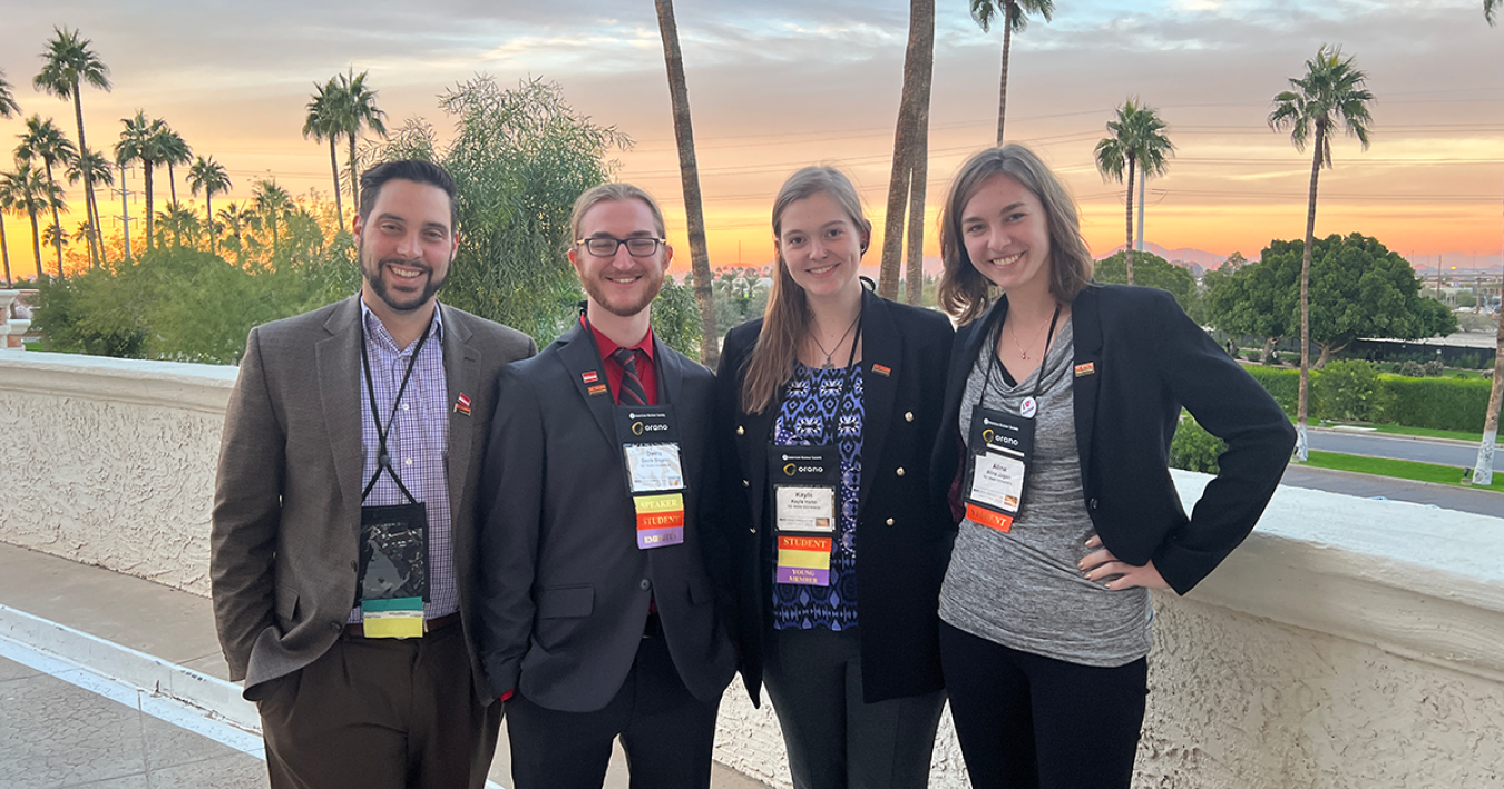 Four NC State University researchers pose in front of a sunset.