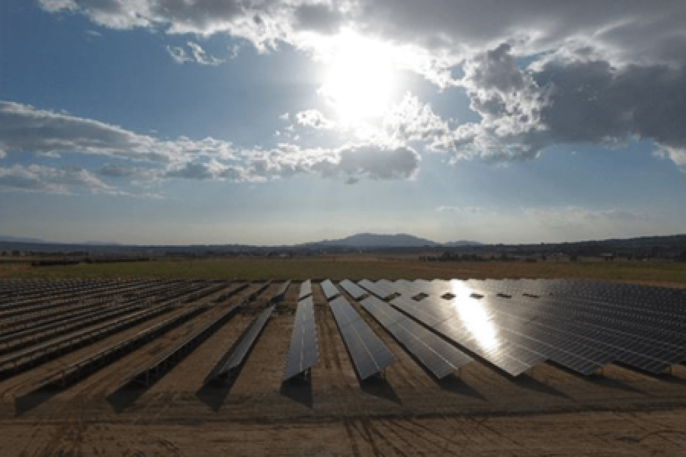 A community solar array underneath beaming sunlight