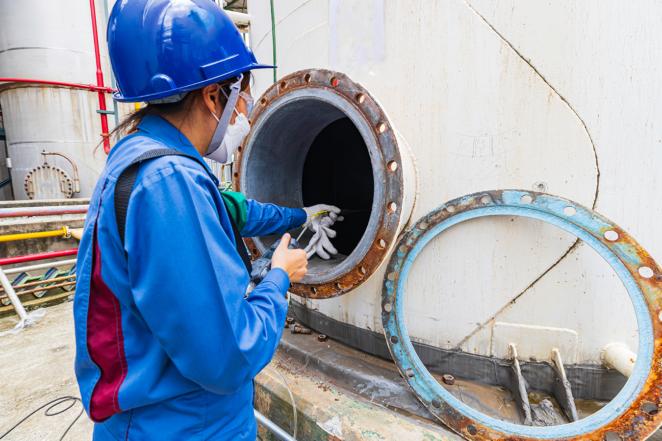 Worker female hand holding gas detector inspection safety gas testing at front manhole tank chemical