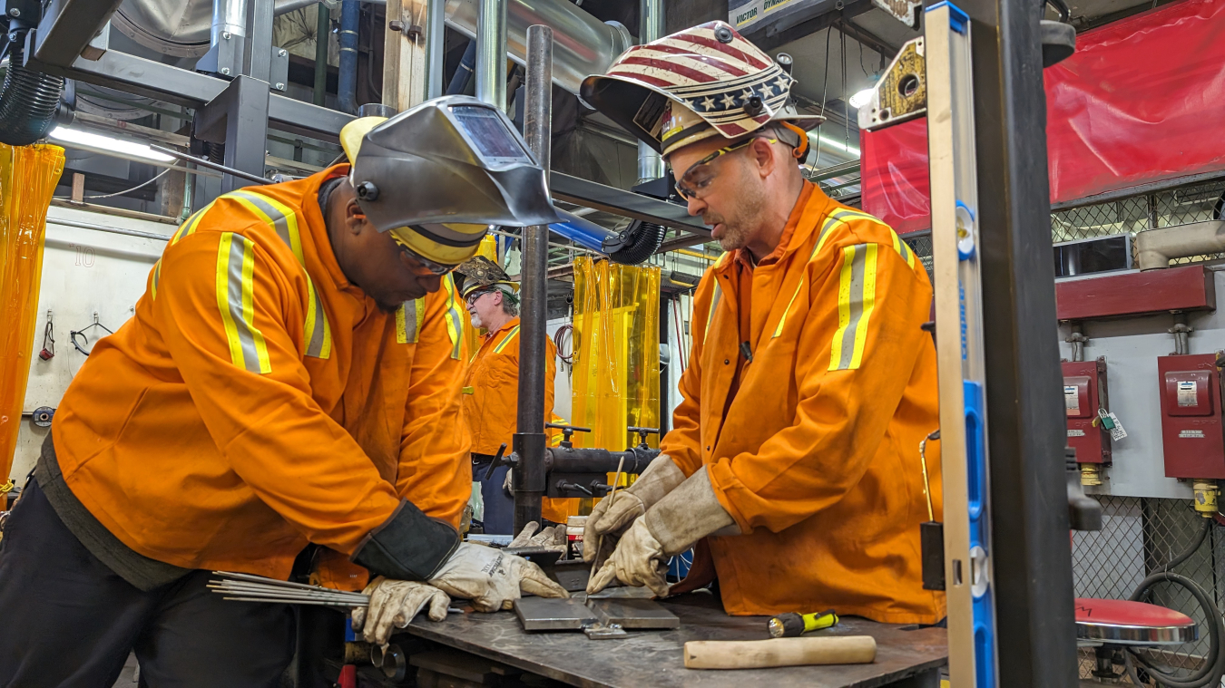 Two Cleveland-Cliffs welders examine task at hand 