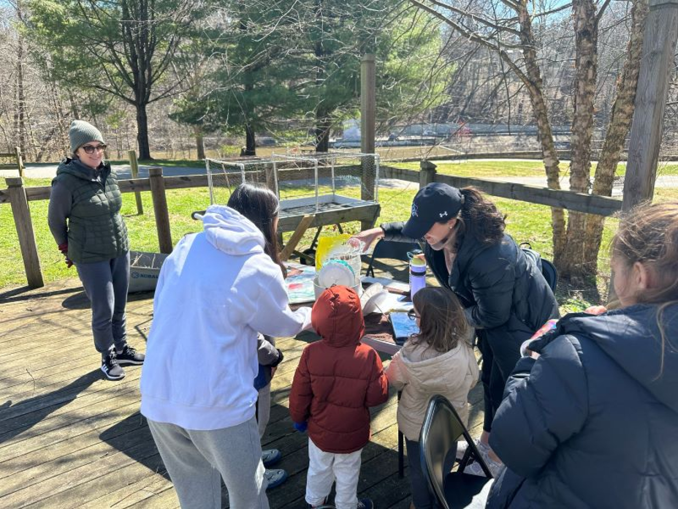 A photo containing four adults and two children in a park setting.