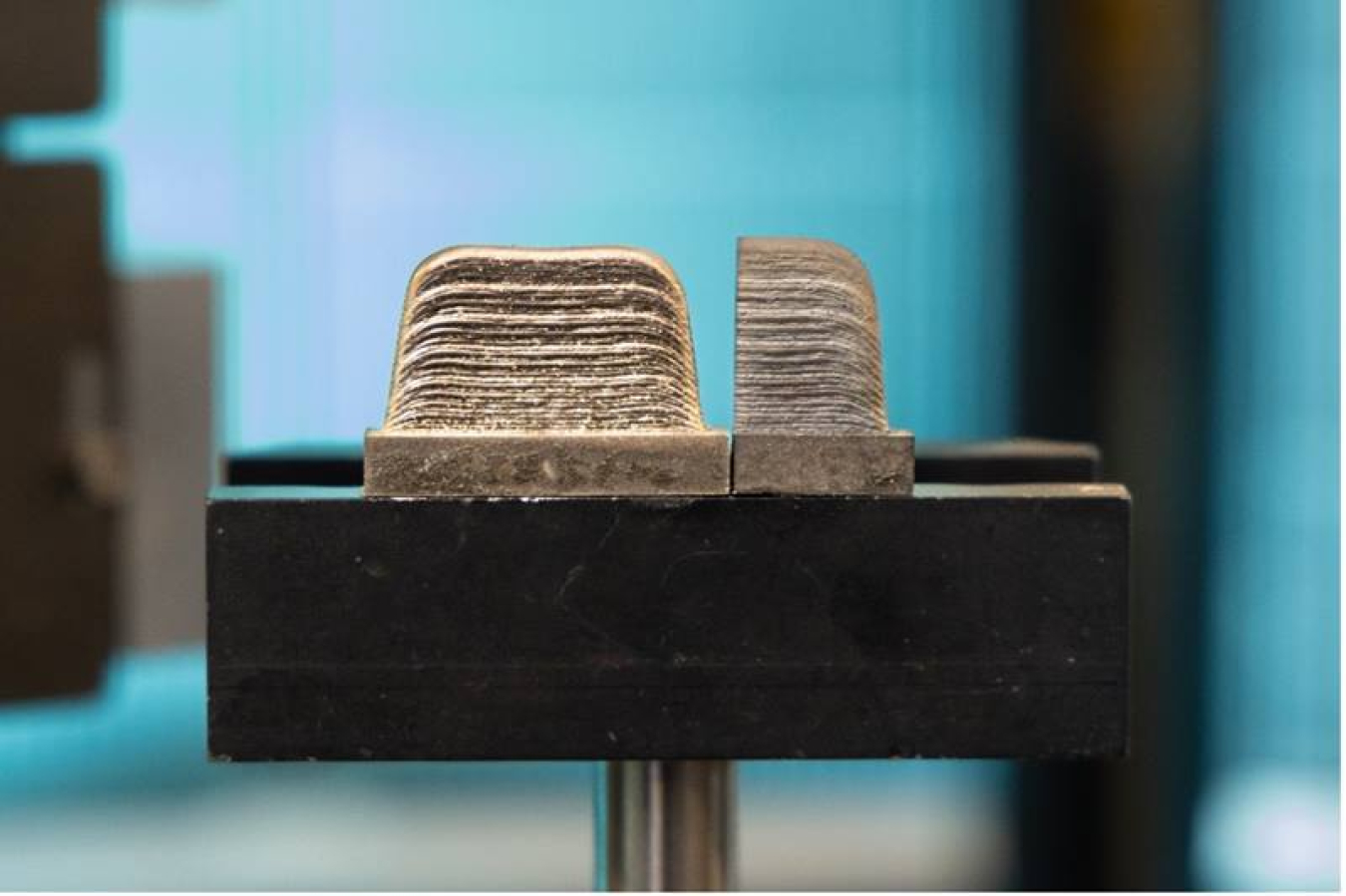 3D-printed metal samples are about 4 inches wide. Printed and heat-treated samples are mounted on a pedestal and exposed to a neutron beam to analyze residual stresses, or irregularities such as cracks or voids, created during the manufacturing process.