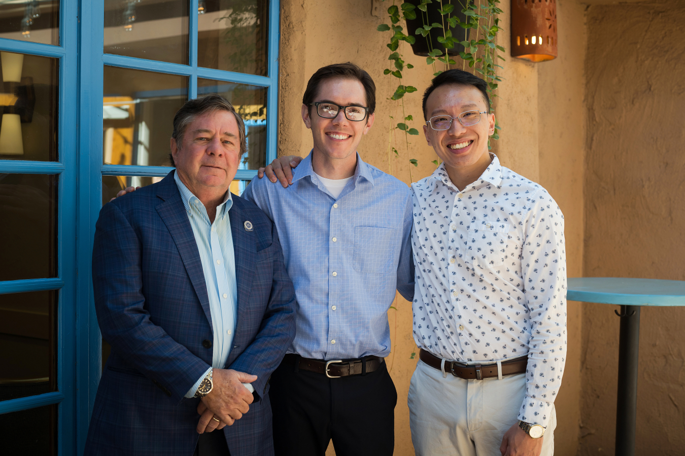 Three people pose and smile for the camera.