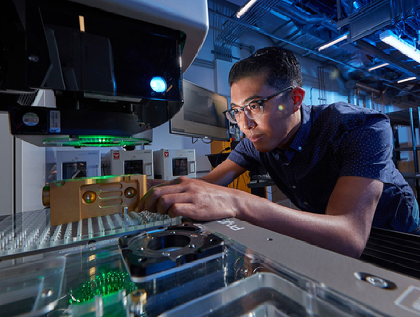 Technician performing additive manufacturing in a lab.