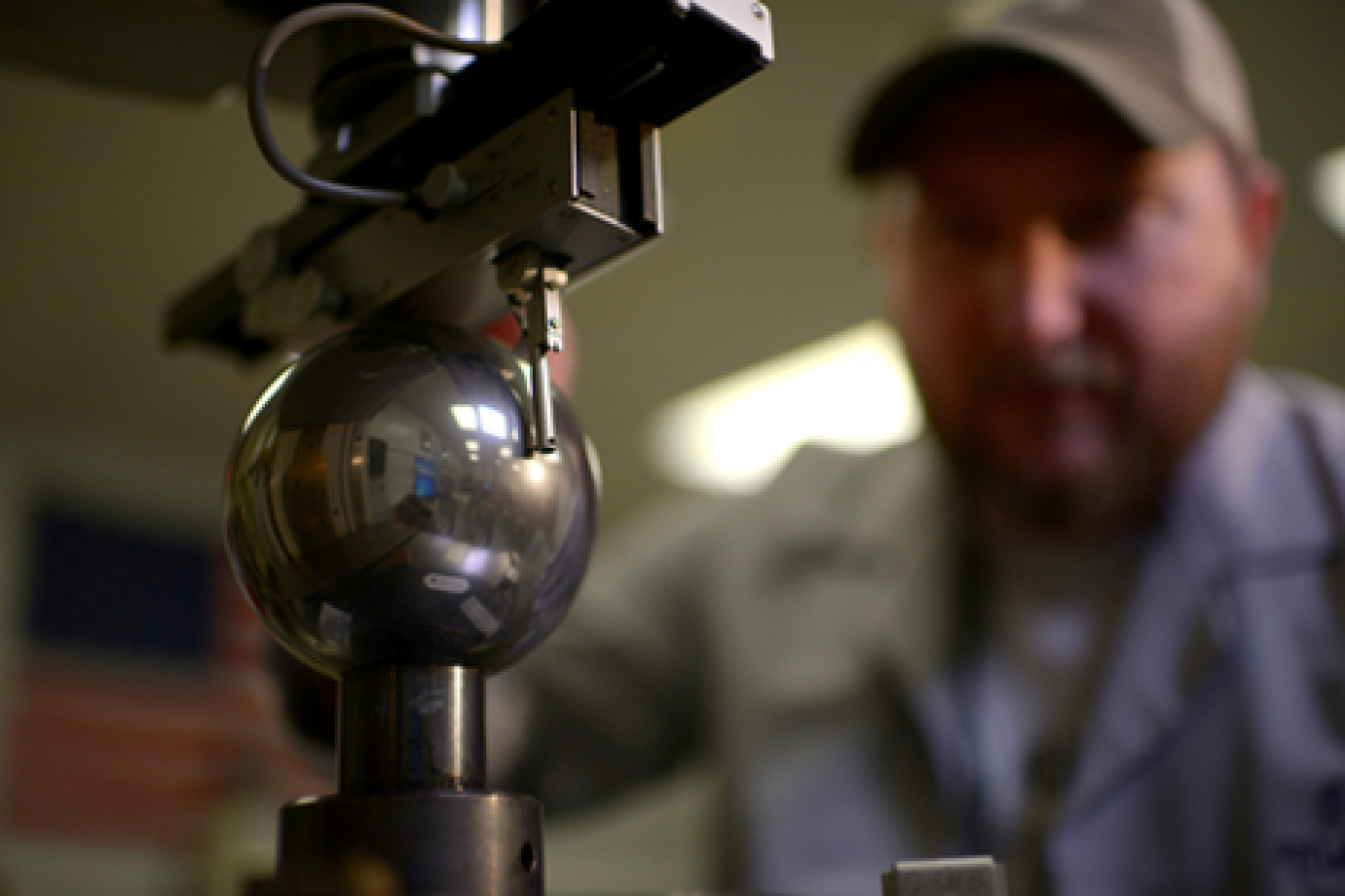 A lab technician looking at a metallic sphere at Y-12 National Security Complex.