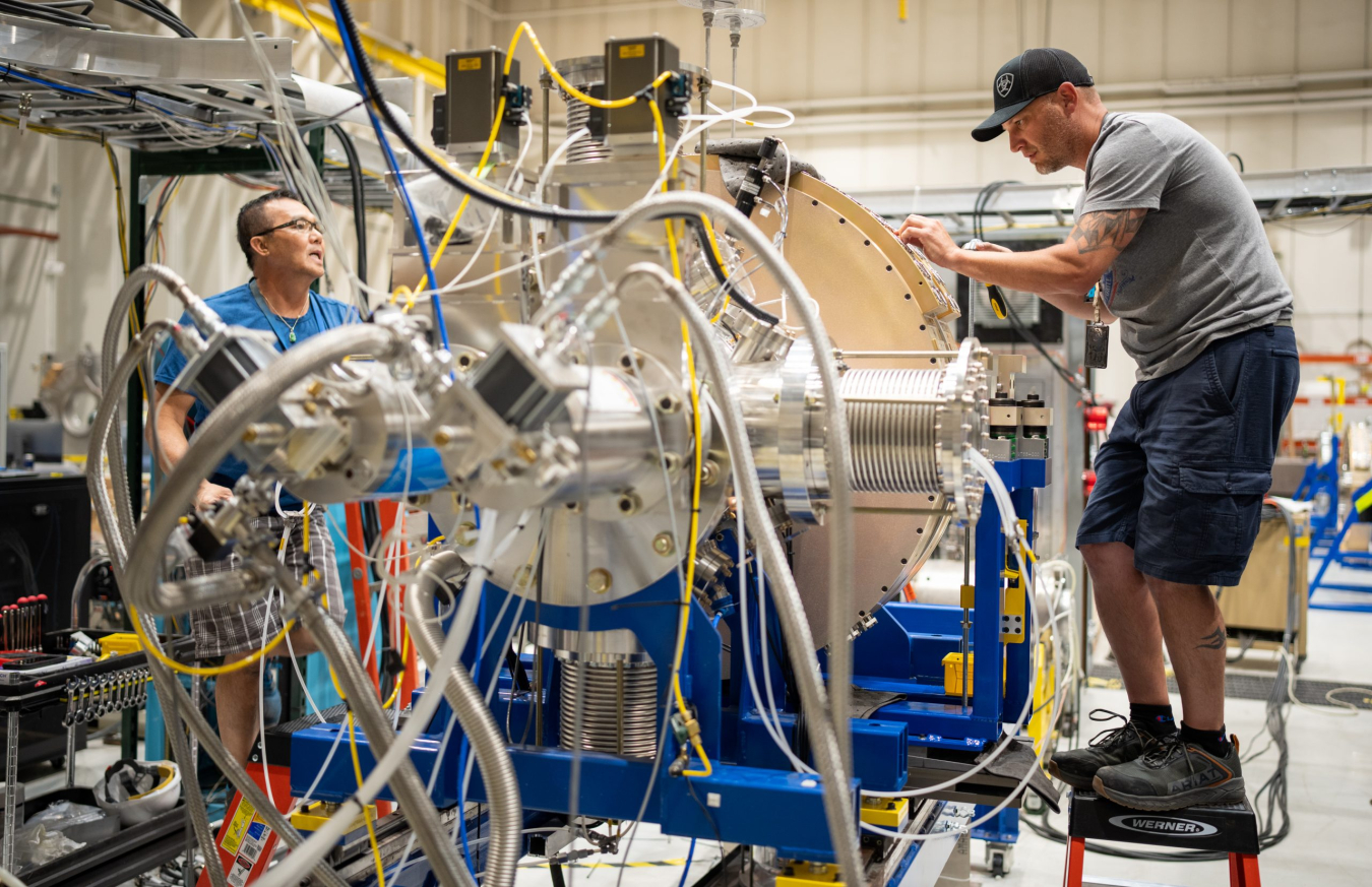 Lab technicians working on machinery.