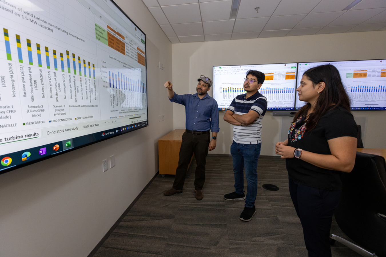 NREL System Dynamics team in front of large screen with data