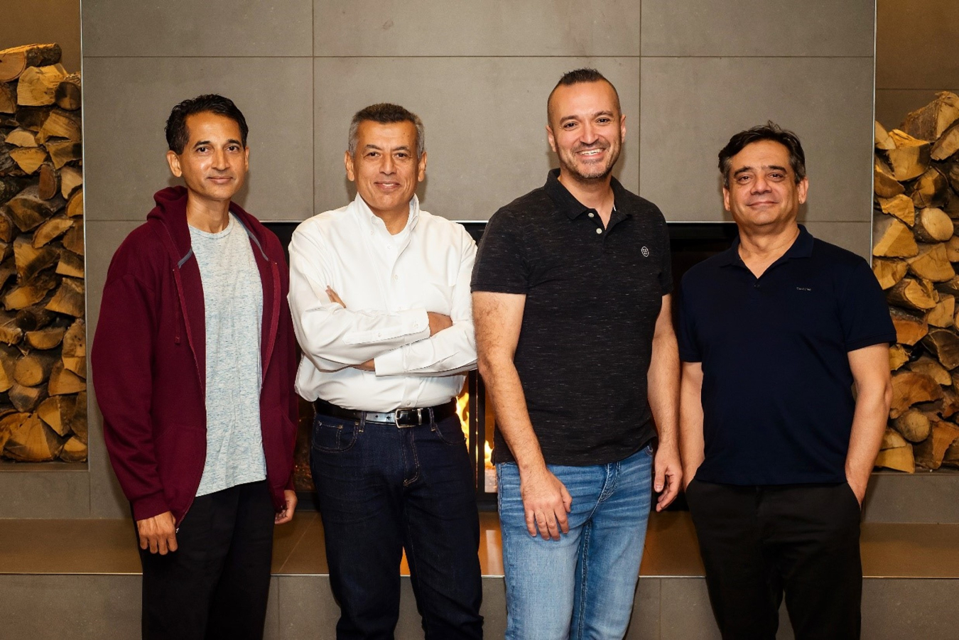 Four men standing and smiling.