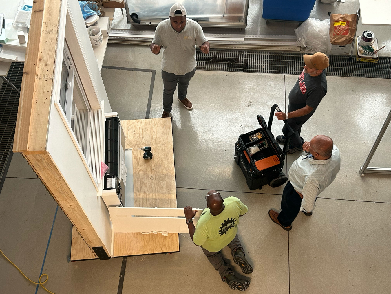 Overhead shot of men working on a window panel.