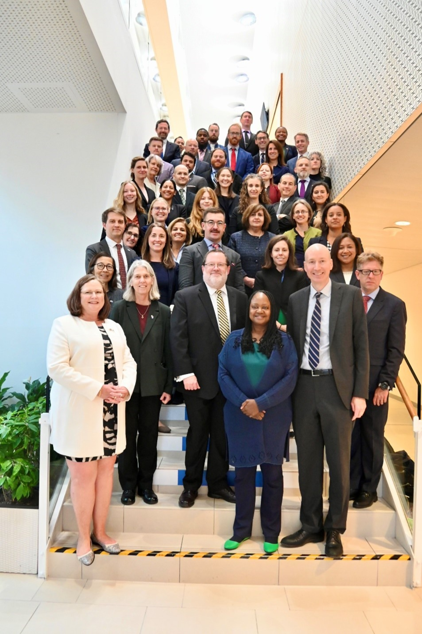 A large group of people pose for a photo on a stairwell.