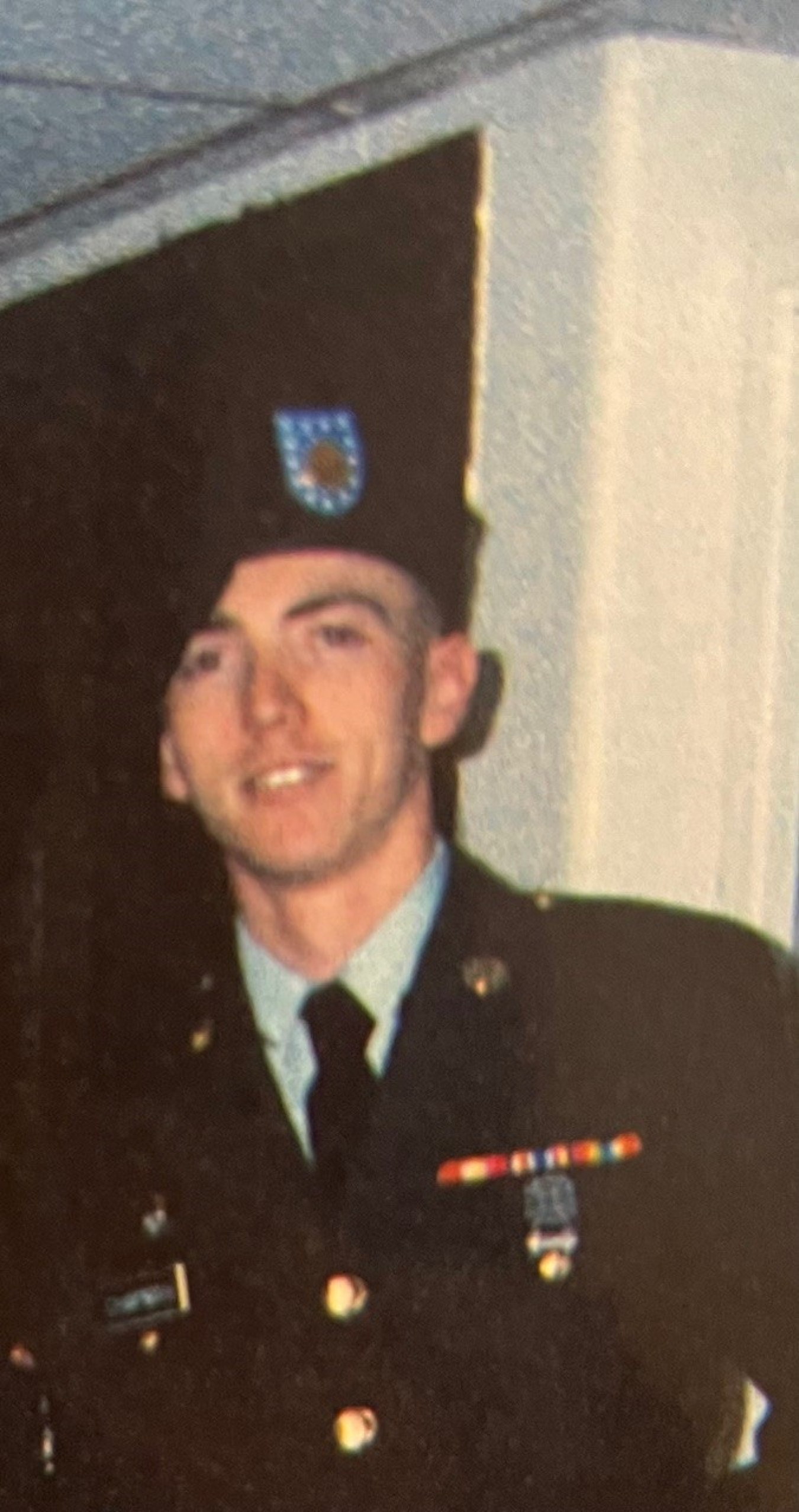 A man in a military uniform poses for a picture