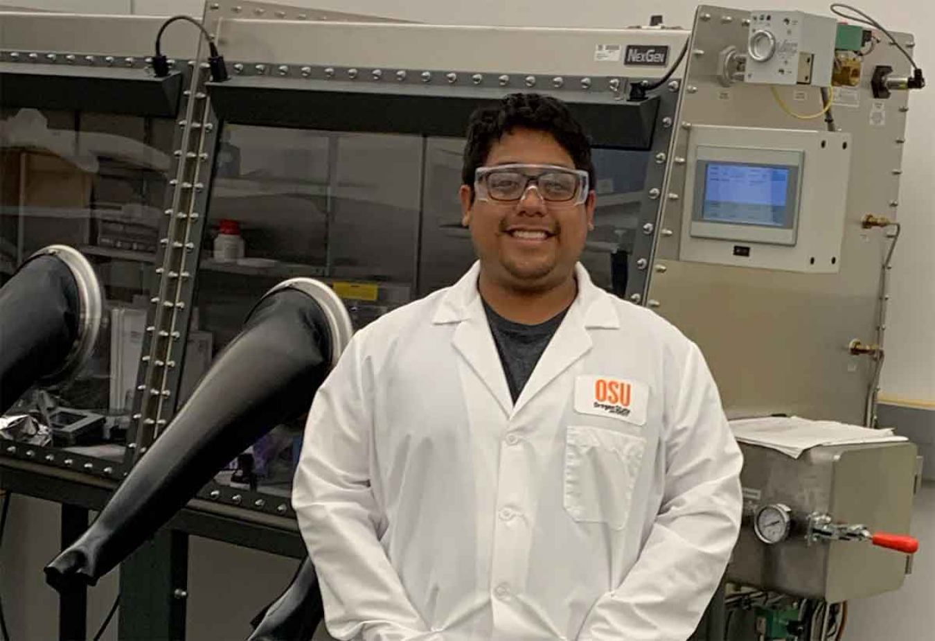 Marcos Lucero wearing a white lab coat in a research lab