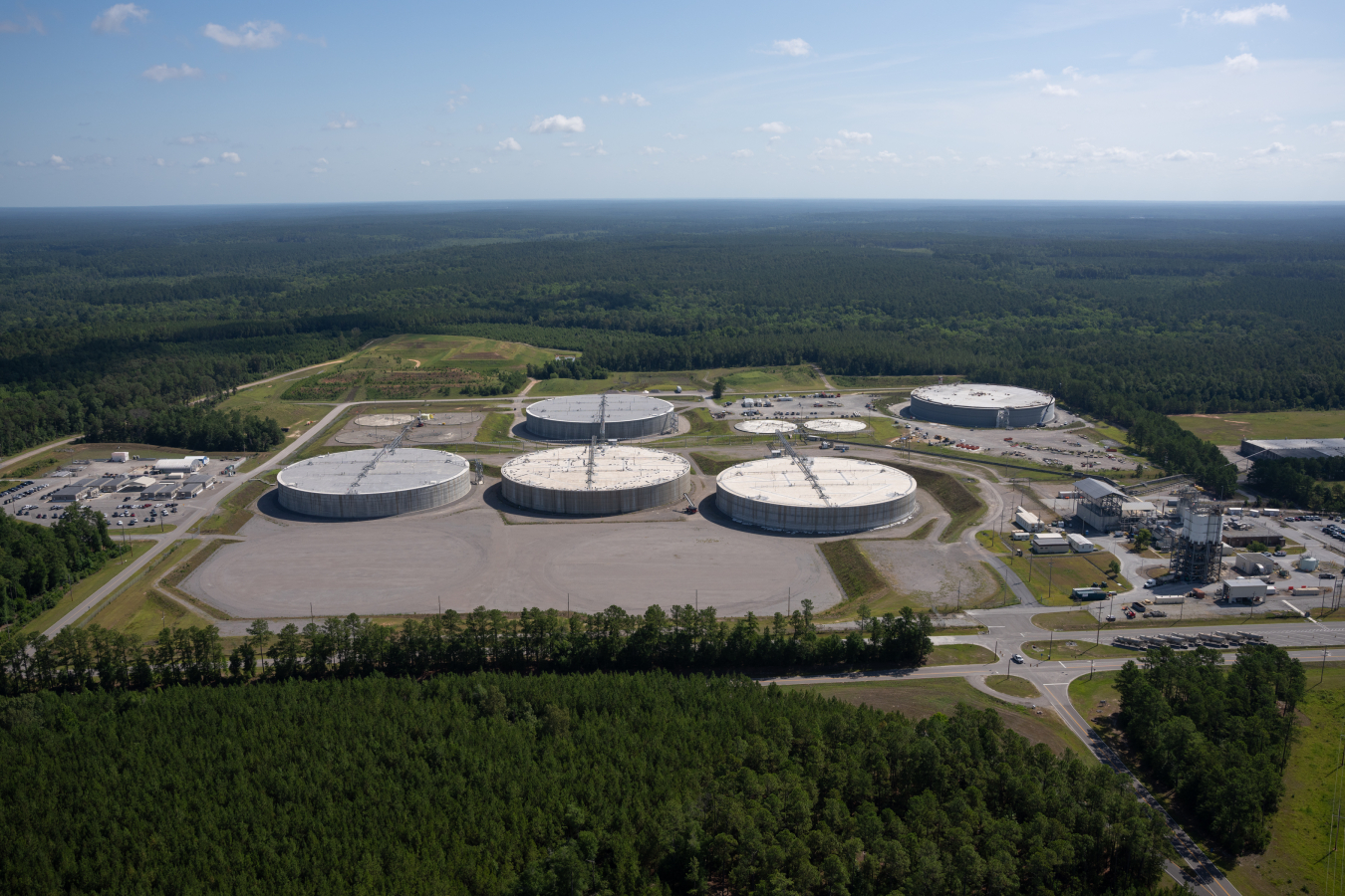 Aerial view of five round white facility buildings