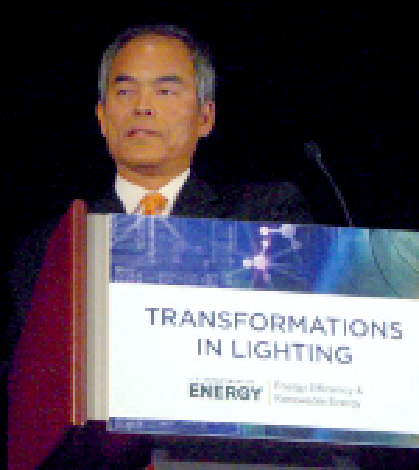 Photo of a man at a podium, with the words Transformations in Lighting on the lectern.