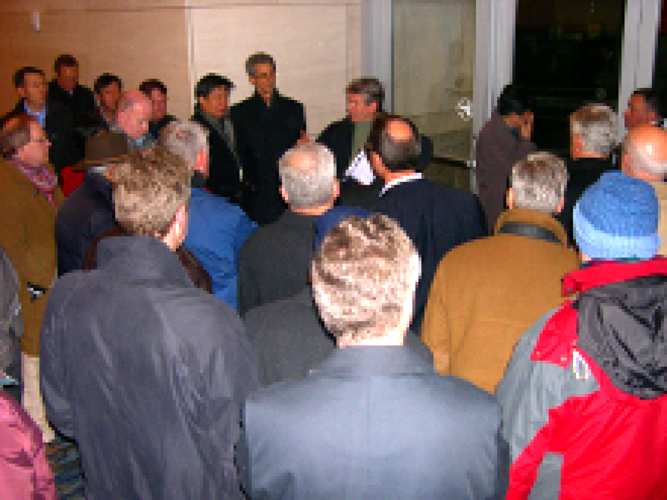 Photo of a group of people standing around a tour-guide leader.