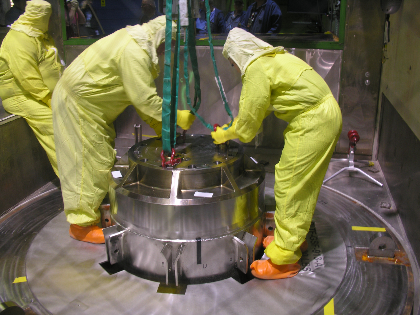 Workers load in irradiated material into shipment cask for transport.