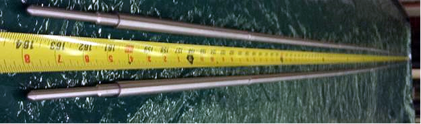 A photo of a nuclear test rod with measuring tape by it