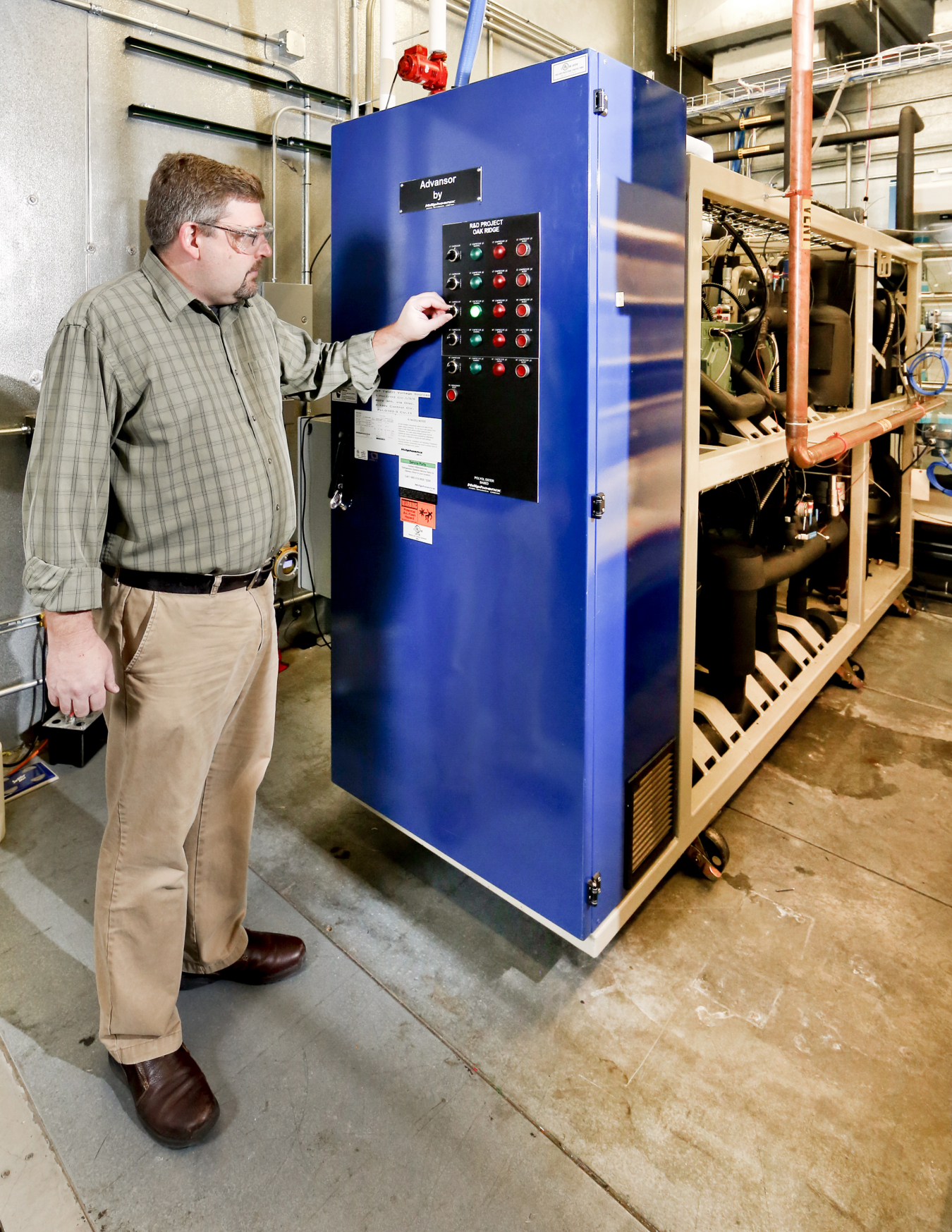 Man standing next to a refrigeration system at the laboratory.