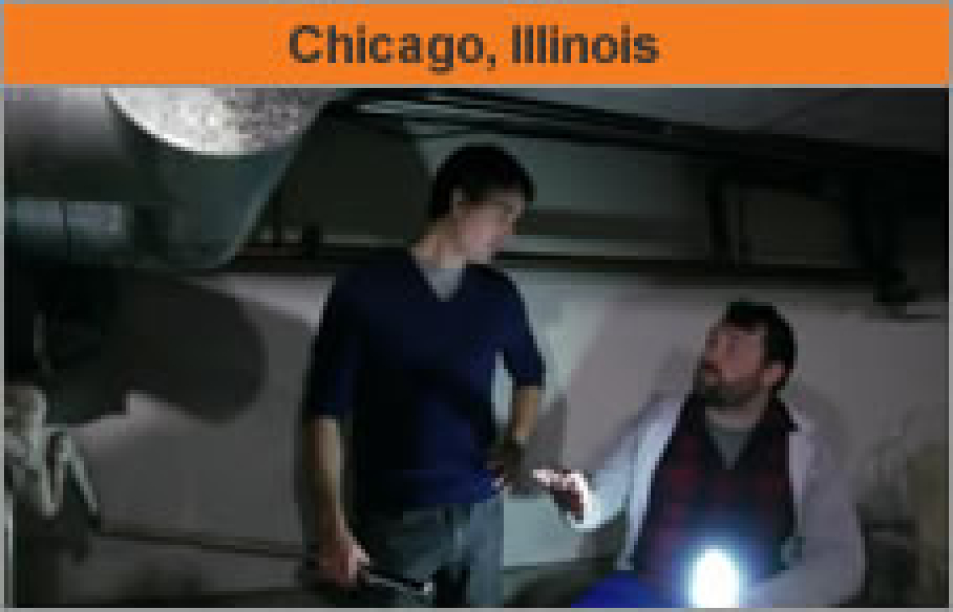 Two men talking near a duct system, with the words, "Chicago, Illinois."