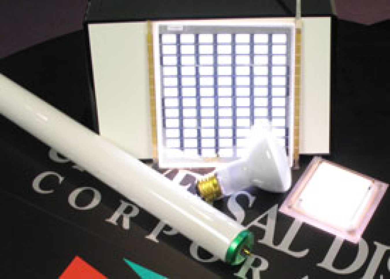 UDC white OLED prototypes are pictured next to fluorescent and incandescent lamps.